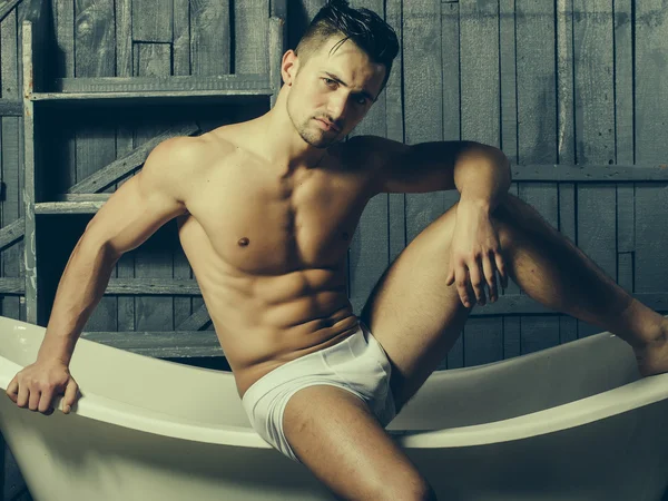 Muscular man on bathtub — Stock Photo, Image