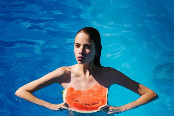 Женщина с арбузом в бассейне — стоковое фото