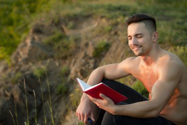 Kitap açık ile gülümseyen kaslı adam