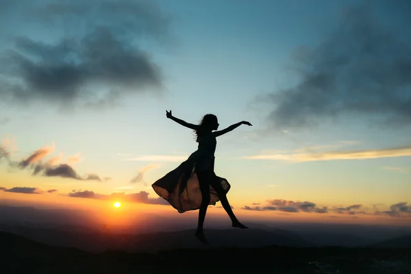 Mujer al atardecer o al amanecer en las montañas — Foto de Stock