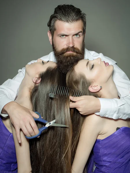 Homme barbu coiffeur et deux femmes — Photo