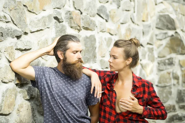 Couple smoking on stony wall background — Stock Photo, Image