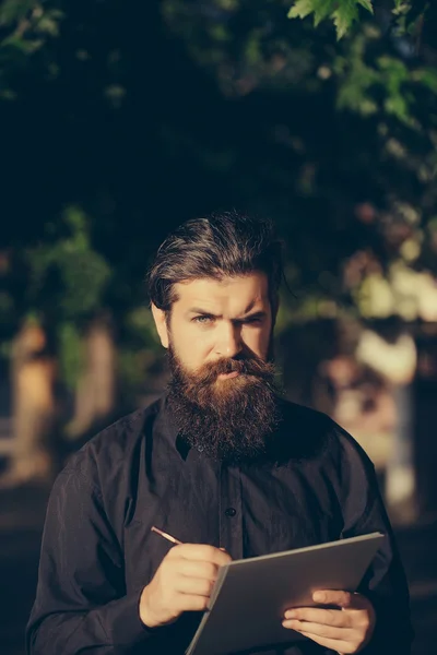 Barbudo hombre al aire libre con lápiz y nota — Foto de Stock