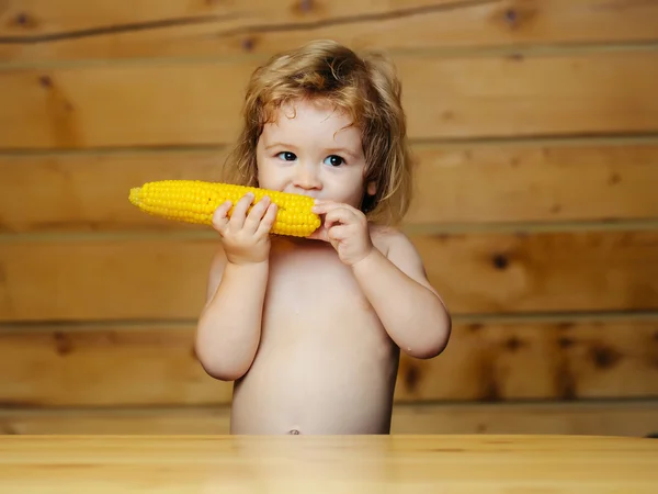 Engraçado menino pequeno criança comendo milho amarelo — Fotografia de Stock