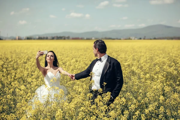Pareja de boda en campo flores amarillas — Foto de Stock
