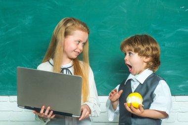Öğretmen ve çocuk. İlkokuldan çocuklar. Okul bahçesindeki ilkokuldan bir oğlan ve kız. Okul çocukları. Sınıfta bir çift küçük kız ve oğlan var..