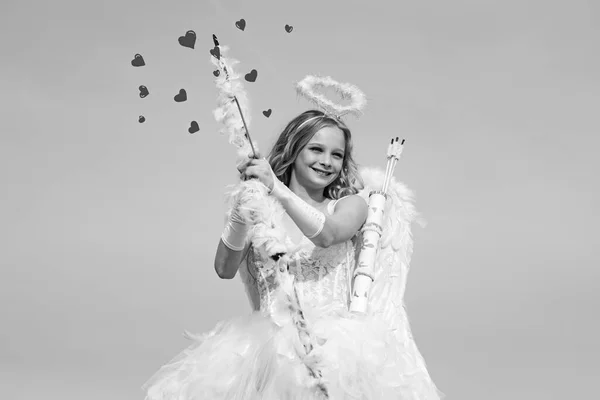 Flecha de amor. Retrato de una niña cupido. Lindo adolescente Cupido en la nube - fondo del cielo. Inocente chica con alas de ángel de pie con arco y flecha contra el cielo azul y nubes blancas — Foto de Stock