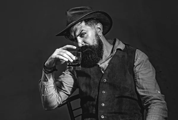 Élégant homme barbu élégant Barman tient verre de whisky. Concept de boisson de luxe. Homme à la mode en chemise blanche et bretelles. — Photo