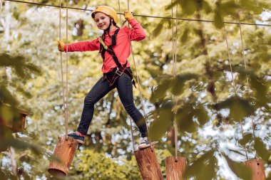 Sanat eserleri, Eko Resort 'ta uçan tilki ya da örümcek ağını içeren oyunları tasvir eder. Dağcı çocuk. Çocuk konsepti. Kask ve güvenlik ekipmanları. Çocuk oyun alanında oynuyor.