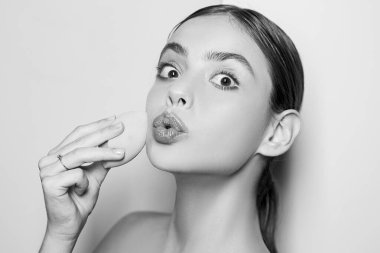 Kapatıcı ve kozmetik fosforlu kalem kullan. Kızın elinde kozmetik aplikatör var. Kadın yüzüne krem sürüyor. Cilt kremi kavramı. Kadın için yüz bakımı. Taze sağlıklı deri konsepti. Mükemmel ten rengi