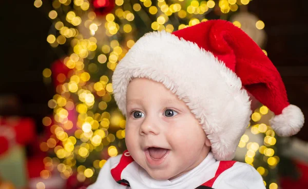 Laughing baby in Santa hat comemora o Natal. Lactente em boné vermelho de Ano Novo. Cara de crianças sorridentes felizes. — Fotografia de Stock