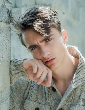 Genç adam kameraya bakıyor. Kendine güveni olan yakışıklı adam..