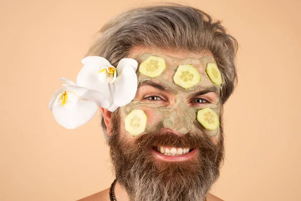 Närbild man ansikte vård. Rolig man med ansiktskräm med gurka. — Stockfoto