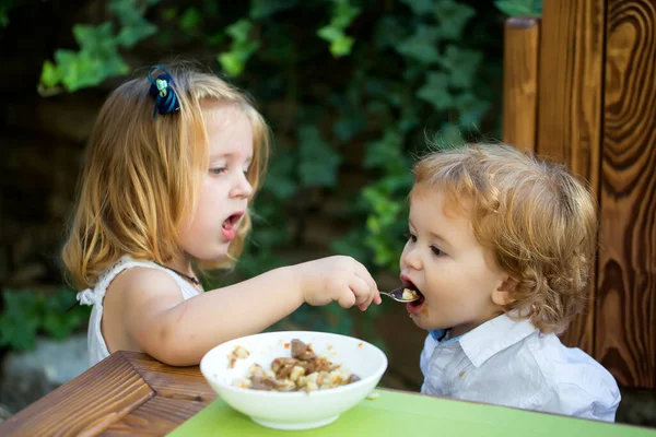 Sorella alimentazione bambino ragazzo con il cucchiaio. — Foto Stock