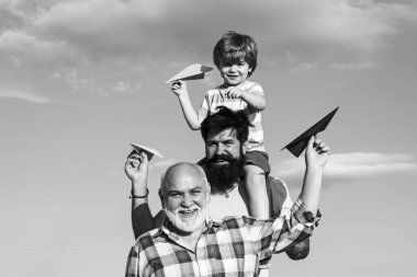 Baba oğul ve büyükbaba birlikte dinleniyorlar. Dedemin oğlu ve torunu parkta eğleniyor. Hafta sonu aile oyunu. Farklı yaşlardaki erkekler..
