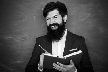 Okuldaki derste sınıftaki masalarda sakallı profesör. Eğitim. Okulda tahtaya yakın bir yerde genç bir öğretmen. Karatahta masasının yanındaki sınıfta arkadaş canlısı bir öğretmen..