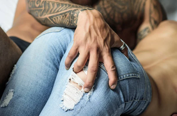 Muscular mans hand on womans butt, takes off her jeans. Intimate relationship and sexual relations. — Stockfoto