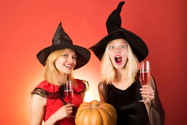 二幸せな若いです女性女の子で魔女ハロウィン衣装上のパーティー上のオレンジ背景. — ストック写真