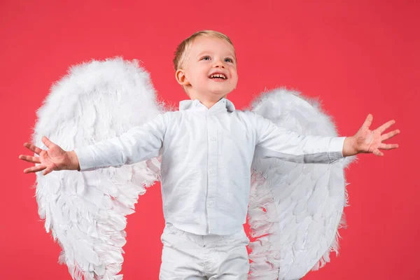 Criança com asas de anjo isoladas em vermelho. — Fotografia de Stock