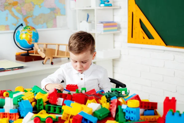 Leerling in de klas. Kind leert in de klas op de achtergrond van schoolbord. Speelgoed voor kleuters en kleuters. — Stockfoto