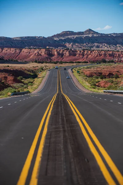 Strada statale che attraversa lo scenario arido del sud-ovest americano con estrema foschia di calore in una calda giornata di sole con cielo blu in estate. — Foto Stock