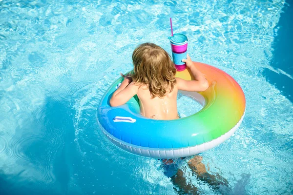 Niño en la piscina, relajarse nadar en el anillo inflable y se divierte en el agua en las vacaciones de verano. —  Fotos de Stock