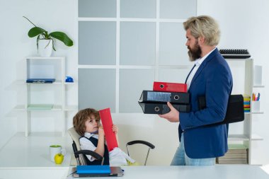 İş arkadaşları beyin fırtınası yapıyor. Şirin çocuk ofis koltuğunda oturuyor kendinden emin büyük patron, komik iş adamı patronluk taslayan çocuk, yönetmen ve güçlü lider kavramı..