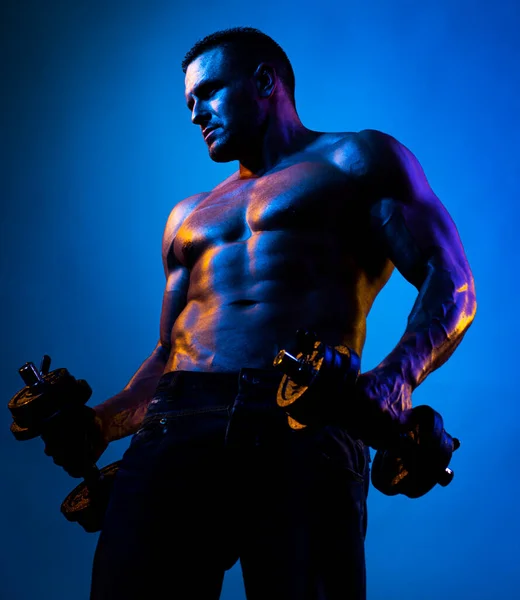 Exercices musculaires homme avec haltères sur néon lumière. — Photo
