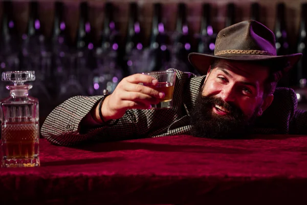 Duygusal, komik sakallı sarhoş hippi elinde cam viski tutuyor. Şerefe.. — Stok fotoğraf