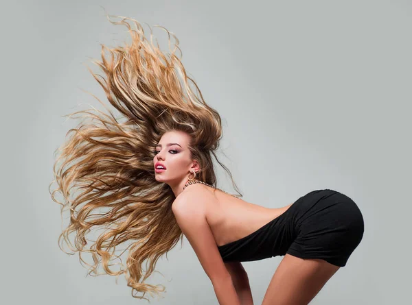 Cabelo em movimento. Rosto da menina bonita com cabelos longos e lisos, posando em estúdio, cinza isolado. Mulher sensual olhar. — Fotografia de Stock