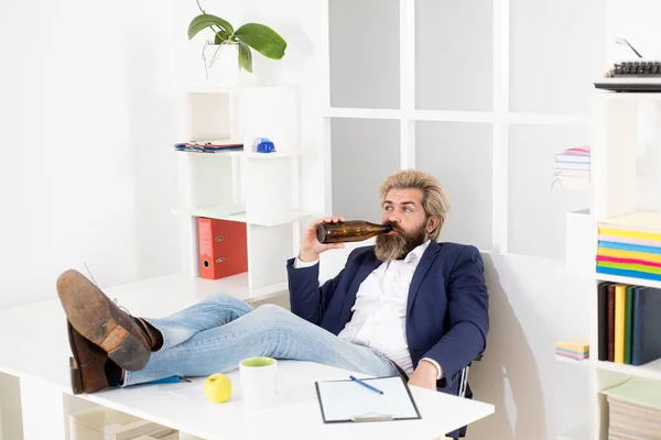 Trieste zakenman eindigde de werkdag met alcohol. Jonge zakenman drinkt op kantoor aan de balie. — Stockfoto