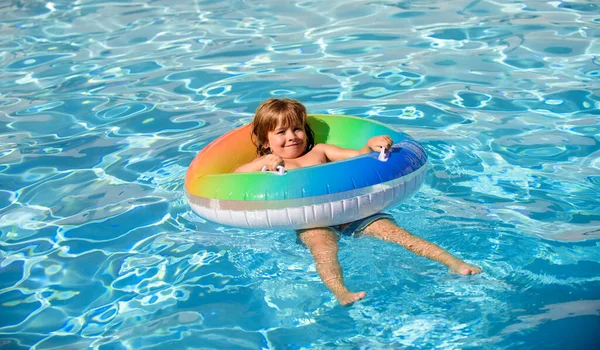 Niño en la piscina, relajarse nadar en el anillo inflable y se divierte en el agua en las vacaciones de verano. —  Fotos de Stock