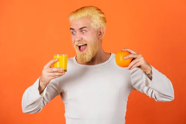 Αστεία ενθουσιασμένος άνθρωπος πίνοντας το χυμό πορτοκάλι. — Φωτογραφία Αρχείου