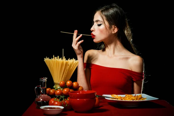 Bella giovane donna con spaghetti tagliatelle, cucina sexy. — Foto Stock