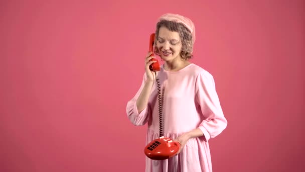 Vrouw met retro telefoon. Sexy pin-up vrouw in het bellen met vintage telefoon geïsoleerd op roze. Grappig callcenter. — Stockvideo