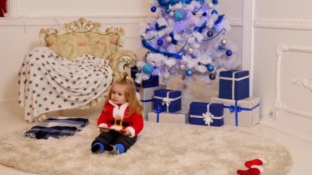 Vánoční a novoroční dítě. Dítě u vánočního stromku a krbu. Krásné dítě si užije Vánoce. Rodinná dovolená. Dětské vzpomínky. — Stock video