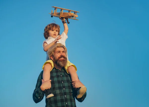 Joyeux père qui se balade sur ses épaules. Père et fils ensemble. Garçon enfant est assis sur l'épaule papa piggyback tandis que le vol. — Photo