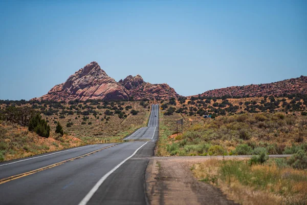 Estrada do deserto ao pôr-do-sol, conceito de viagem, EUA. Asfalto estrada e desfiladeiro fundo. — Fotografia de Stock