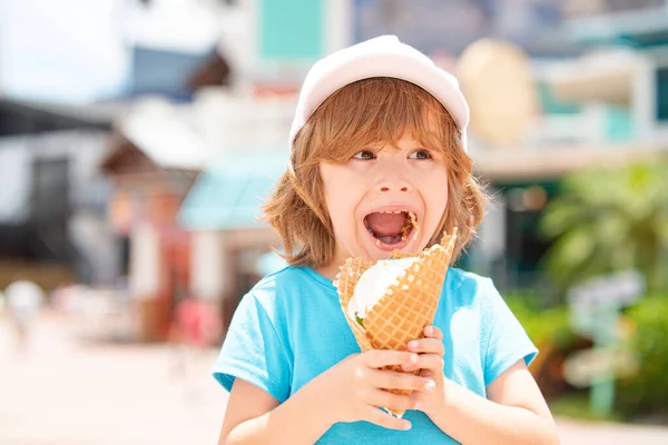 Lindo niño comiendo lamiendo helado grande en gofres cono feliz riendo en el fondo al aire libre. —  Fotos de Stock