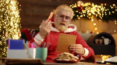 Evde Noel Baba dilek listesi mektubunu okuyor..