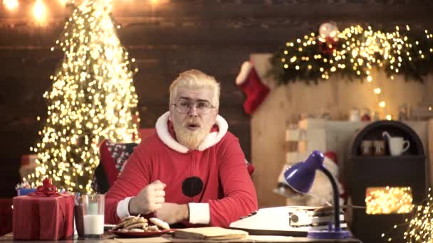 Санта Клаус сидит дома на диване и переключает телеканалы. Сосредоточься на дистанционном управлении. Концепция Рождества и Нового года. — стоковое видео