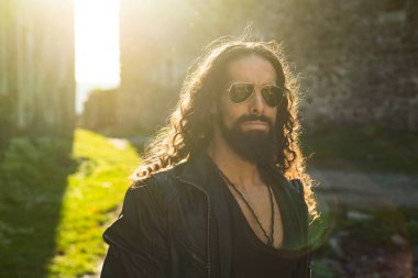 Moda erkek modeli. Seksi bir adam. Tarz ve trend. Güzellik konsepti. Şık saç kesimi, saç stili. Uzun saç stili.