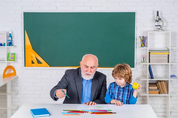 Nagyapa és fia együtt tanulnak. Egy magabiztos öreg férfi tanár portréja. A nyugdíjkorhatár fogalma. A nagyapa és a fia az osztályban tanulnak.. — Stock Fotó