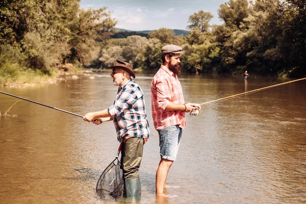 Pescadores con cañas de pescar en sombreros. Un fin de semana perfecto. Atrapar con éxito. Atrápame si puedes. Pescador mostrar técnica de pesca utilizar la caña. Hombre guapo relajándose. Pasarlo bien.. —  Fotos de Stock