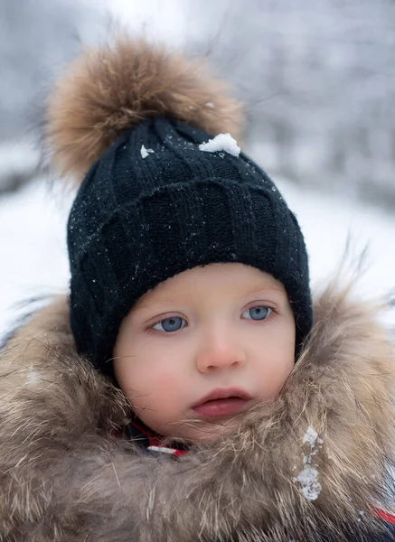 겨울 옷을 입은 귀여운 소년. 겨울 옷을 입은 아이는 눈 아래를 걷습니다. 귀엽기도 해라. 눈 속의 작은 소년의 모습. 매력적 인 소년. 야외에서 즐거운 시간을 보내는 동안. — 스톡 사진
