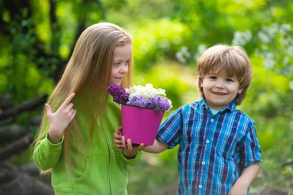 Crianças bonitos jardinagem e plantio de flores no chão no jardim da primavera, atividades ao ar livre sazonais, infância feliz. — Fotografia de Stock