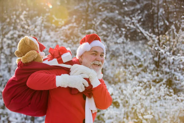 サンタの祖父は贈り物を届けます。雪の冬の山のサンタクロース。新年とクリスマスが近づいています. — ストック写真