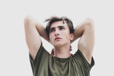 Stüdyo fotoğrafında genç adam yukarı bakıyor. Kendine güveni olan yakışıklı adam..