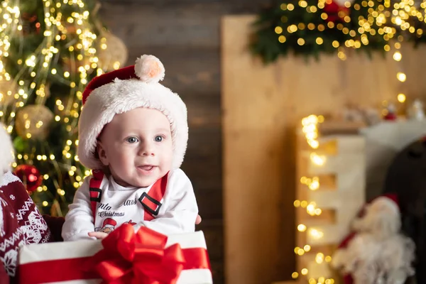 Um bebé a usar chapéu de Pai Natal. Retrato de bebê engraçado no chapéu de Natal. Diversão de ano novo. — Fotografia de Stock