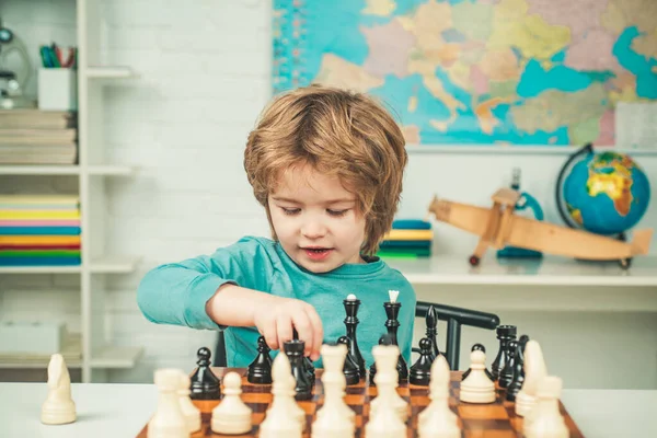 Gelukkig kind en jeugd. Schaakstrategie. Hij schaakt. Geconcentreerde jongen die schaakstrategie ontwikkelt, bordspel speelt. — Stockfoto